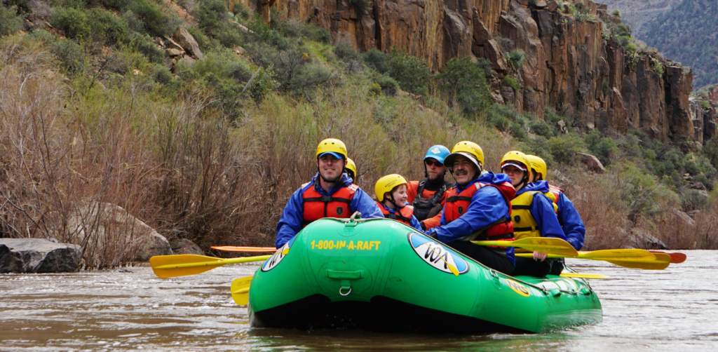 People in the desert in a green raft on the salt river