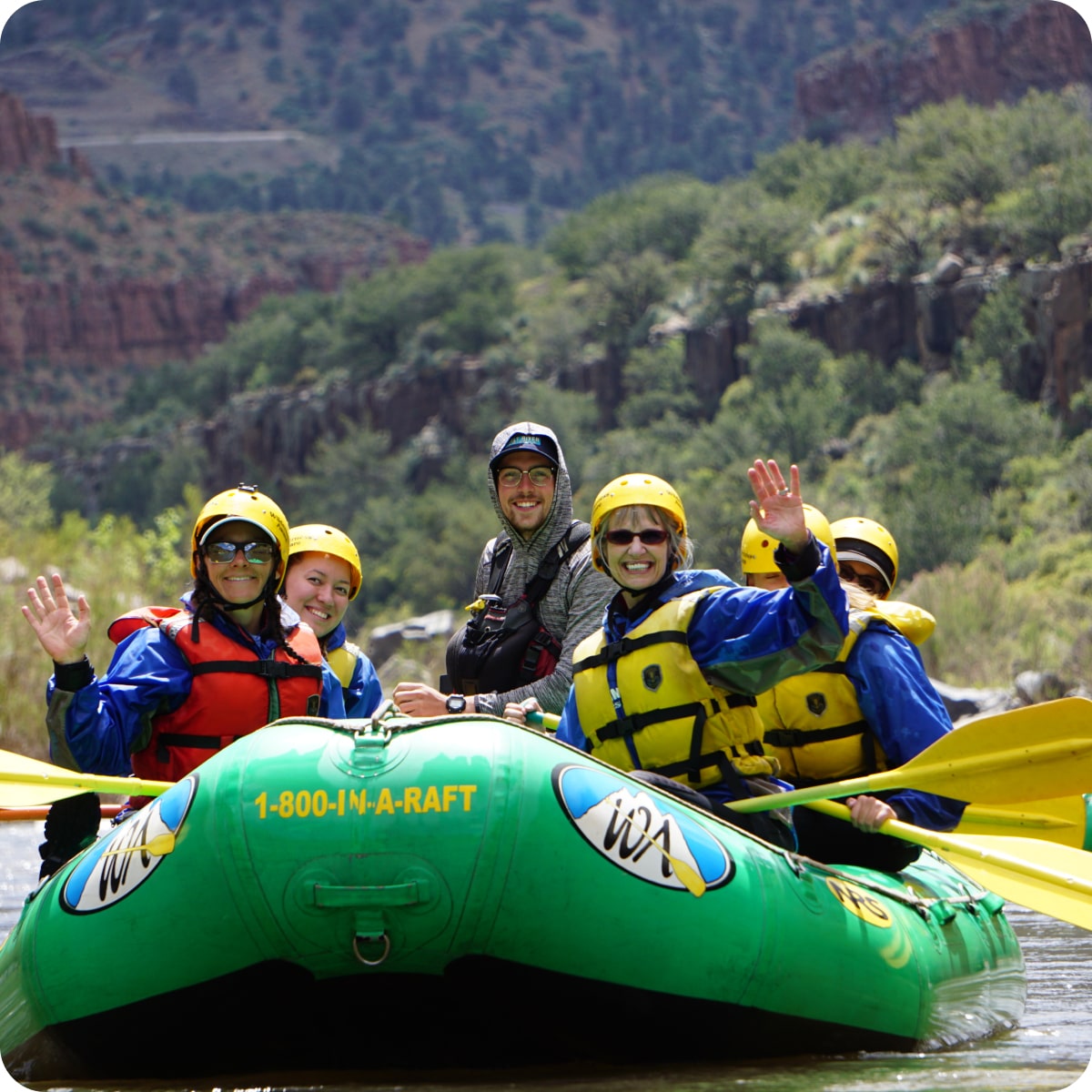 A group of rafters smile and wave on the Salt River