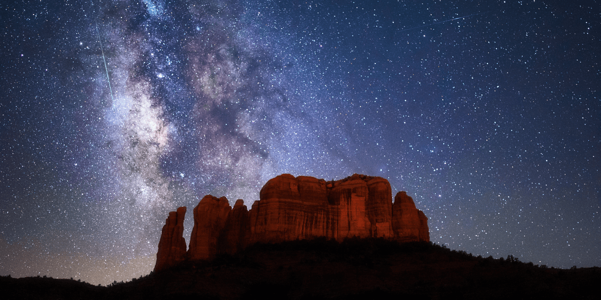 stars in the night sky over red rocks in sedona arizona